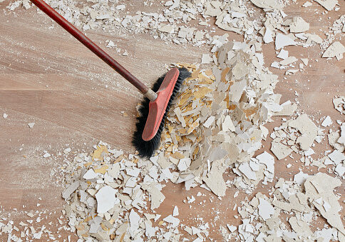Builder sweeping the floor after renovation